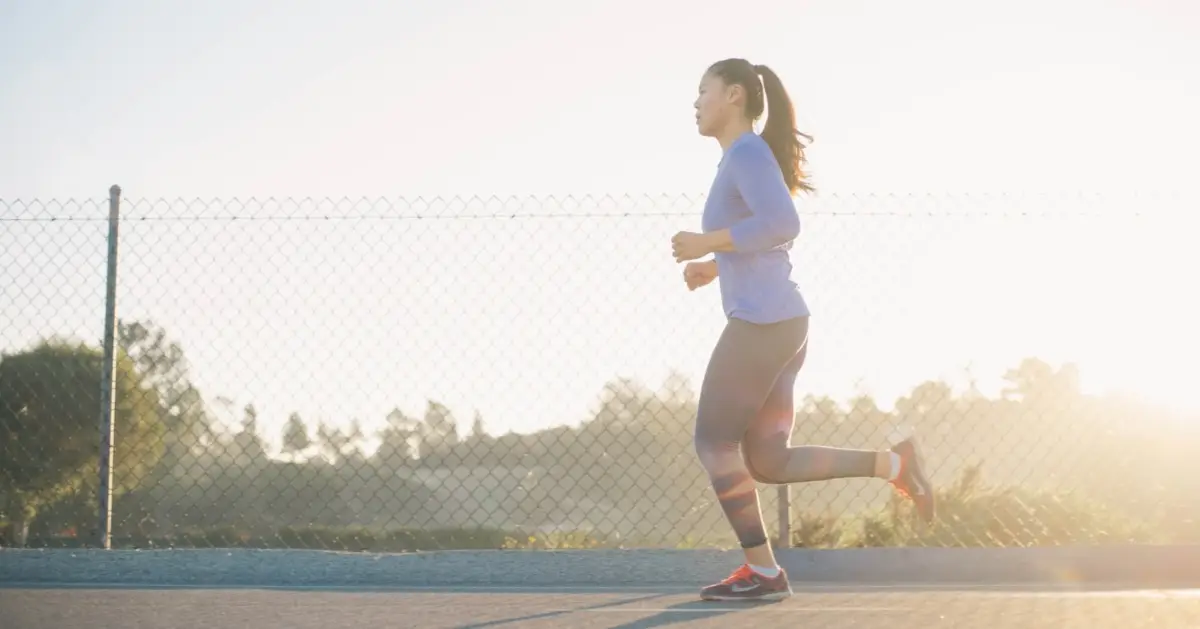 woman jogging near wire fence